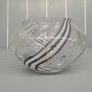 以下が含まれることがあります： 白と黒の線が渦巻く模様の透明なガラスボウル。ボウルは直径約10cmです。
