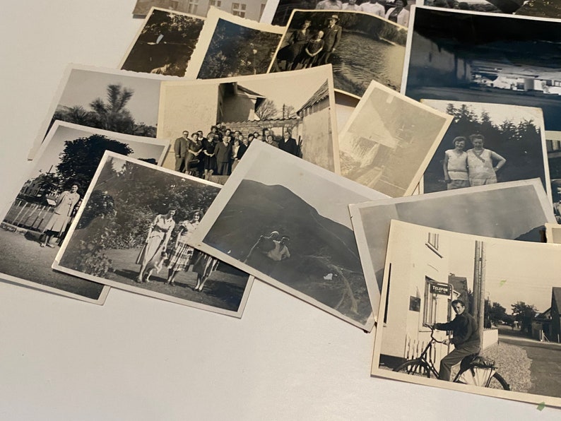Puede incluir: Una colecci&oacute;n de fotograf&iacute;as antiguas en blanco y negro, algunas con personas, otras con paisajes y otras con edificios. Las fotos est&aacute;n dispuestas en una pila sobre una superficie blanca.