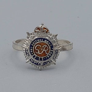 May include: Silver ring with a blue and orange enamel design featuring a crown and the letters "ER" surrounded by text.