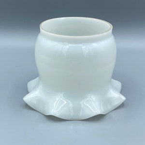 Puede incluir: Pantalla de lámpara de vidrio blanco opaco con borde festoneado. La pantalla tiene un cuerpo bulboso y una parte superior acampanada. La forma general recuerda a una flor. Medidas en centímetros.