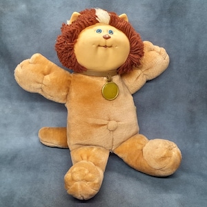 Muñeca Cabbage Patch Kids Koosas Brownie el Gato León de 1983, diseñada como mascota para la línea original de muñecas - Cabeza de plástico y cuerpo de peluche - 37 cm de altura