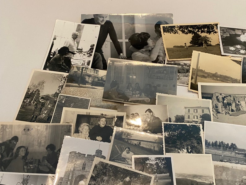 May include: A collection of vintage black and white photographs, depicting various scenes. The images show people, landscapes, and buildings, creating a nostalgic feel. The photographs are arranged in a layered composition.