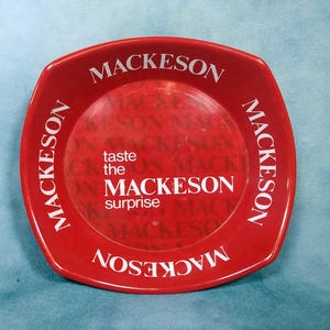 May include: Red plastic ashtray with the words "Mackeson" and "taste the Mackeson surprise" printed in white.