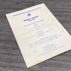 May include: A black and white document with the title "London Amateur Boxing Association Annual Report 1975-1976" and a list of names and titles.