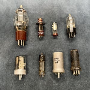 Peut inclure: Collection de tubes à vide vintage, avec des composants en verre et en métal. Les tubes varient en taille et en forme, avec des structures internes et des broches de base visibles. Certains ont des bases marron ou noires, d'autres des finitions argentées ou transparentes.
