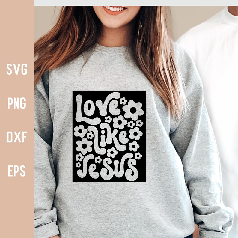 K&ouml;nnte beinhalten: Ein graues Sweatshirt mit einer schwarzen quadratischen Grafik, auf der in Wei&szlig; "Love like Jesus" steht, umgeben von wei&szlig;en Blumen.