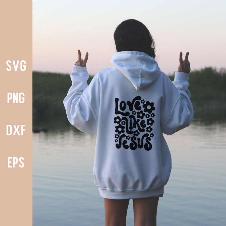 K&ouml;nnte beinhalten: Ein wei&szlig;er Hoodie mit einer schwarzen Grafik auf der R&uuml;ckseite, die "Love like Jesus" mit Blumen um den Text herum sagt.