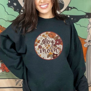 May include: A black sweatshirt with a floral design and the text "dog mom" in a circle.