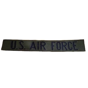 May include: A green fabric patch with the text "U.S. AIR FORCE" in black.