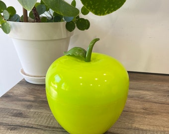 Vintage geïsoleerde ijsblokjesemmer in de vorm van een bijna neon groene appel met steel en blad