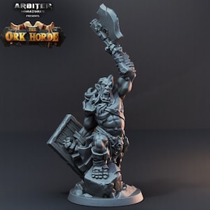May include: A gray miniature of an orc warrior, holding a large axe aloft and a shield. The orc is muscular and detailed, standing on a rocky base. The text "The Ork Horde" is visible in the upper left corner.