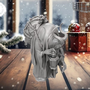 以下が含まれることがあります： 角と背中に袋、手に提灯を持った生き物のグレーの細かいフィギュア。フィギュアは雪が降る冬の背景に置かれています。