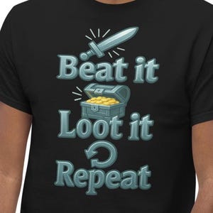 May include: Black t-shirt with a graphic design featuring a sword, a treasure chest filled with gold coins, and the words "Beat it, Loot it, Repeat" in a stylized font. The design has a gaming theme.
