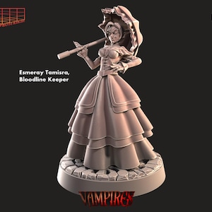 Op de afbeelding: Een geschilderd miniatuurbeeldje van een vrouwelijke vampier in een lange jurk en met een paraplu. Het beeldje staat op een voet met het woord "Vampires" erop. Het beeldje is geschilderd in een lichtbruine kleur.