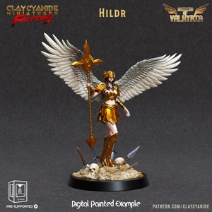Puede incluir: Una figura miniatura pintada en oro de una guerrera con alas, sosteniendo una lanza y vistiendo un casco y una armadura. La figura está de pie sobre una base con calaveras y otros detalles. El texto "HILDR" es visible en el fondo.