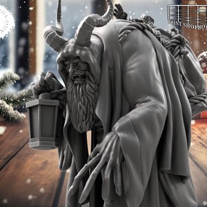 以下が含まれることがあります： 角、長いひげ、ランタンを持った生き物のグレーの細かいフィギュア。生き物は長いローブを着ており、腰にロープが結ばれています。フィギュアは雪の背景に置かれています