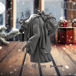 以下が含まれることがあります： 角とあごひげ、背中に袋を背負った生き物のグレーのミニチュアフィギュア。生き物は左手に提灯を持っており、木製の表面に立っています。フィギュアの高さは約5cm、幅は約4.8cmです。