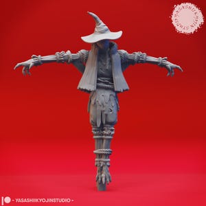 Könnte beinhalten: Eine graue, 3D-gedruckte Vogelscheuchenfigur mit ausgestreckten Armen, die einen spitzen Hut und zerlumpte Kleidung trägt. Die Figur ist mit Seilen gebunden und hat ein detailliertes, strukturiertes Aussehen. Der Hintergrund ist einfarbig rot.