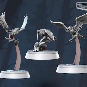 Peut inclure: Trois figurines détaillées d'aigles gris avec des ailes déployées et perchées sur des socles. Les aigles sont dans diverses poses, l'un d'eux tenant un petit objet. Les bases sont blanches et les supports sont de couleur marron clair. Le texte "STL Miniatures" est visible.