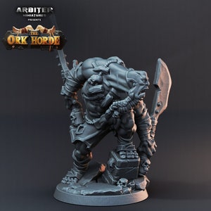 K&ouml;nnte beinhalten: Eine graue Plastik-Miniaturfigur eines Ork-Kriegers, der ein gro&szlig;es Schwert und einen kleineren Dolch h&auml;lt. Der Ork tr&auml;gt einen Lendenschurz und hat einen grimmigen Gesichtsausdruck. Die Figur steht auf einem felsigen Sockel.