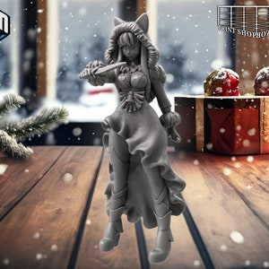 Peut inclure: Une figurine en 3D imprimée en gris d'un personnage féminin portant un manteau d'hiver à capuche, une robe et des bottes. Elle tient un couteau dans sa main droite et a une expression déterminée sur son visage.