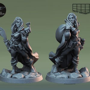 Pode incluir: Duas miniaturas pintadas de cinza que representam personagens femininas. Uma figura segura uma adaga e uma pequena garrafa. A outra figura segura uma bolsa e uma pequena garrafa. Ambas as figuras estão em pé sobre uma base redonda.