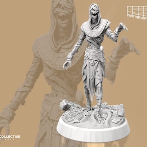 May include: A white painted miniature figurine of a mummy with a skeletal face and a cloth wrapped body. The mummy is standing on a base with a sand-like texture and hieroglyphics.