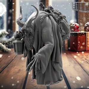 以下が含まれることがあります： 角が生えていて、長いひげを生やした灰色の姿が、背中に袋を背負い、提灯を持っています。その姿は長いローブを着ており、歩いているようです。背景は雪景色で、木製のテーブルと赤いギフトボックスがあります。