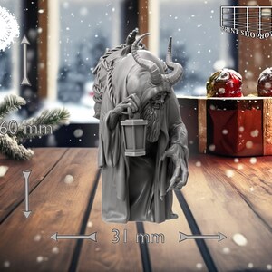 以下が含まれることがあります： 角とあごひげ、ランタンを持った生き物のグレーの3Dプリントフィギュア。フィギュアの高さは60mm、幅は31mm。雪の降る背景の、木製の表面に立っています。