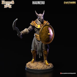 Könnte beinhalten: Eine bemalte Miniaturfigur eines Schakal-Kriegers, Haunebu, aus dem Spiel Echoes of the Nile. Die Figur trägt eine goldene Rüstung und hält ein gebogenes Schwert und einen Schild.