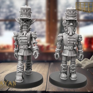 Könnte beinhalten: Zwei grau bemalte Nussknacker-Figuren, eine mit einem Schädelgesicht und die andere mit einem Bart, beide tragen eine Militäruniform mit einer roten Schärpe und einem hohen Hut.