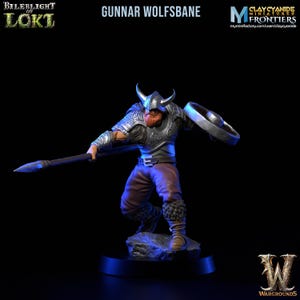 Puede incluir: Una figura en miniatura pintada de un guerrero con barba, que lleva un casco y una armadura, sosteniendo una lanza y un escudo. La figura está en posición de combate. La figura está pintada en plata, marrón y rojo. La figura está de pie sobre una base.