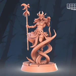 May include: A 3D-printed figurine of a female fantasy character in a dynamic pose. She wears armor, a flowing skirt, and a crown, holding a staff with a crescent moon and floral accents. The figurine is a light orange-brown color and stands on a circular base.