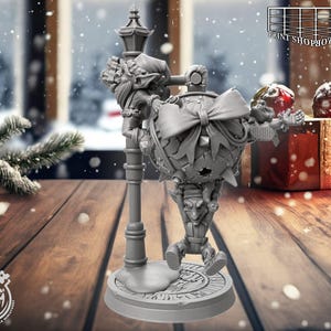 May include: A grey 3D-printed Christmas ornament with a whimsical design. The ornament is a sphere with a large bow, supported by a figure holding a lamppost. The base has the text "Cast n Play".