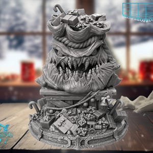 Könnte beinhalten: Eine graue, 3D-gedruckte Skulptur eines monströsen Weihnachtssacks, der mit Geschenken und Zuckerstangen überquillt. Der Sack hat ein bedrohliches Gesicht mit scharfen Zähnen und steht auf einem Holzsockel mit weiteren Geschenken und einer Spielzeugeisenbahn. Das Witchsong-Logo ist sichtbar.