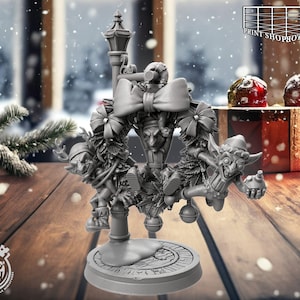 Puede incluir: Una corona navideña gris impresa en 3D con figuras de elfos, un lazo y un diseño de farola. La corona está sobre una base redonda con el logo "Cast n Play". El fondo muestra una ventana nevada y decoraciones navideñas.