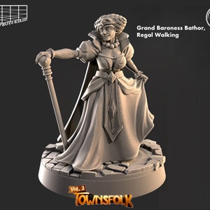 May include: A grey 3D printed miniature of a woman in a long dress and a crown, holding a staff. The miniature is standing on a stone base. The text "Grand Baroness Bathor, Regal Walking" is printed on the base. The text "Vol. 2 Townsfolk" is printed on the base.