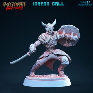 May include: White painted miniature figure of a warrior with a sword and shield. The figure is wearing armor and has a horned helmet. The figure is standing on a base.