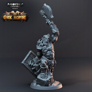 K&ouml;nnte beinhalten: Eine graue Plastikminiatur eines Ork-Kriegers, der eine gro&szlig;e Axt und einen Schild h&auml;lt. Der Ork tr&auml;gt eine R&uuml;stung und hat einen grimmigen Gesichtsausdruck. Die Miniatur steht auf einem felsigen Sockel.