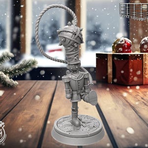 May include: A gray 3D-printed nutcracker figurine with a circular base and a rope-like handle. The figurine is wearing a military-style uniform and has a raised leg. The background includes a snowy window and gift boxes, suggesting a holiday theme.