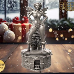 Könnte beinhalten: Eine silberne Figur einer Frau mit Flügeln, die auf einer Weihnachts-Musikbox steht. Die Musikbox hat einen Kamin und einen Weihnachtsbaum.