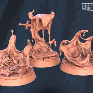 Può includere: Tre miniature in resina stampate in 3D di una sostanza viscosa e appiccicosa, ciascuna con un oggetto diverso intrappolato al suo interno. La prima miniatura mostra una spada bloccata nella sostanza viscosa, la seconda mostra una gabbia toracica e la terza mostra un piccolo forziere di legno.