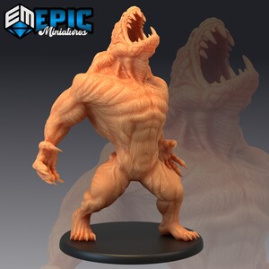 Puede incluir: Una miniatura impresa en 3D de una criatura monstruosa con una gran boca, dientes afilados y un cuerpo musculoso. La criatura está pintada de color marrón claro y está de pie sobre una base negra.