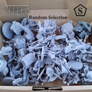 May include: A box filled with a random selection of gray miniature figurines. The figurines depict various fantasy characters, creatures, and objects. The text "Random Selection" is visible on the box.