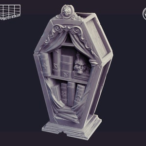 Könnte beinhalten: Ein graues, 3D-gedrucktes Bücherregal in Sargform mit einem Schädel und Büchern im Inneren. Das Bücherregal hat eine dekorative Oberseite und eine Basis. Das Bücherregal wird von Cast & Play hergestellt.