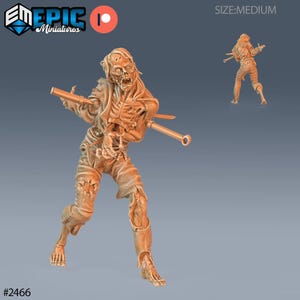 Puede incluir: Figura en miniatura detallada de un zombi, posando en una postura de acción dinámica. La figura es de color marrón claro, con características esqueléticas visibles y ropa hecha jirones. Sostiene dos armas cilíndricas. Una versión más pequeña de la figura está en el fondo. El texto "SIZE:MEDIUM" y "#2466" es visible.