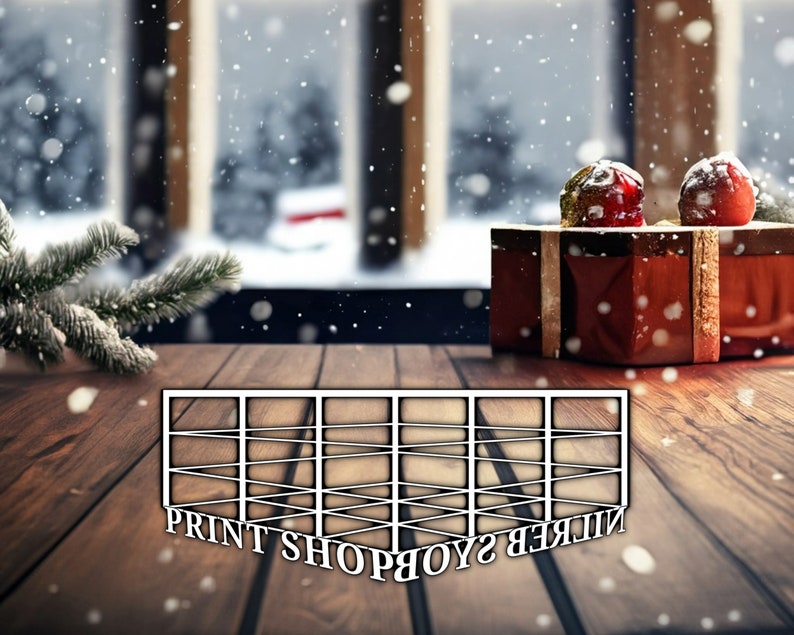 以下が含まれることがあります： 黒い文字で「PRINT SHOP」と書かれた白い木製のフレーム。フレームは赤いギフトボックスとクリスマスツリーの枝を背景に、木製のテーブルの上に置かれています。シーンは軽い雪で覆われています。
