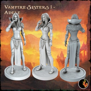 May include: A grey painted miniature figurine of a female vampire with long hair, wearing a long dress and a fur collar. The figurine is standing on a round base. The text "Vampire Sisters 1 - Adele" is visible at the top of the image.