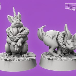 Puede incluir: Dos figuras grises de fantasía de un conejo con un cuerno de unicornio. Una figura está sentada, la otra está en cuclillas. Ambas tienen un cuello peludo y están sobre una base con detalles de hojas. El fondo es morado.