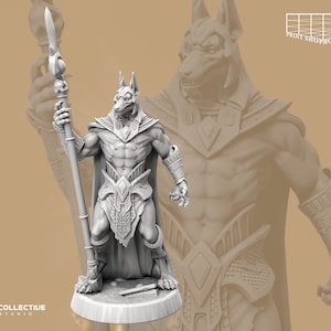 Könnte beinhalten: Eine weiße 3D-gedruckte Miniatur einer jackal-köpfigen humanoiden Figur, die einen Stab mit einer Speerspitze hält. Die Figur trägt einen Lendenschurz und einen Umhang. Die Miniatur steht auf einem runden Sockel.